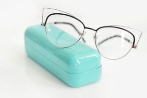 Glasses case with fashionable glasses on white background