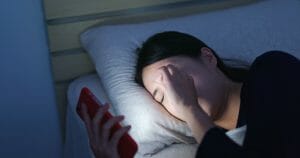 Woman feeling eye pain and lying on bed at night