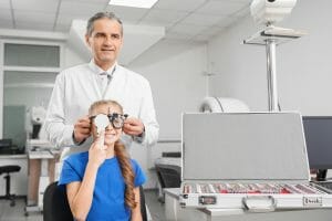 Professional ophthalmologist checking eyesight of girl.