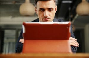 Confident businessman sitting with tablet computer