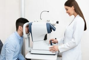 Optometrist checking patients vision at modern clinic