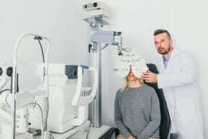 Eye doctor checking patient's eyes on a machine.